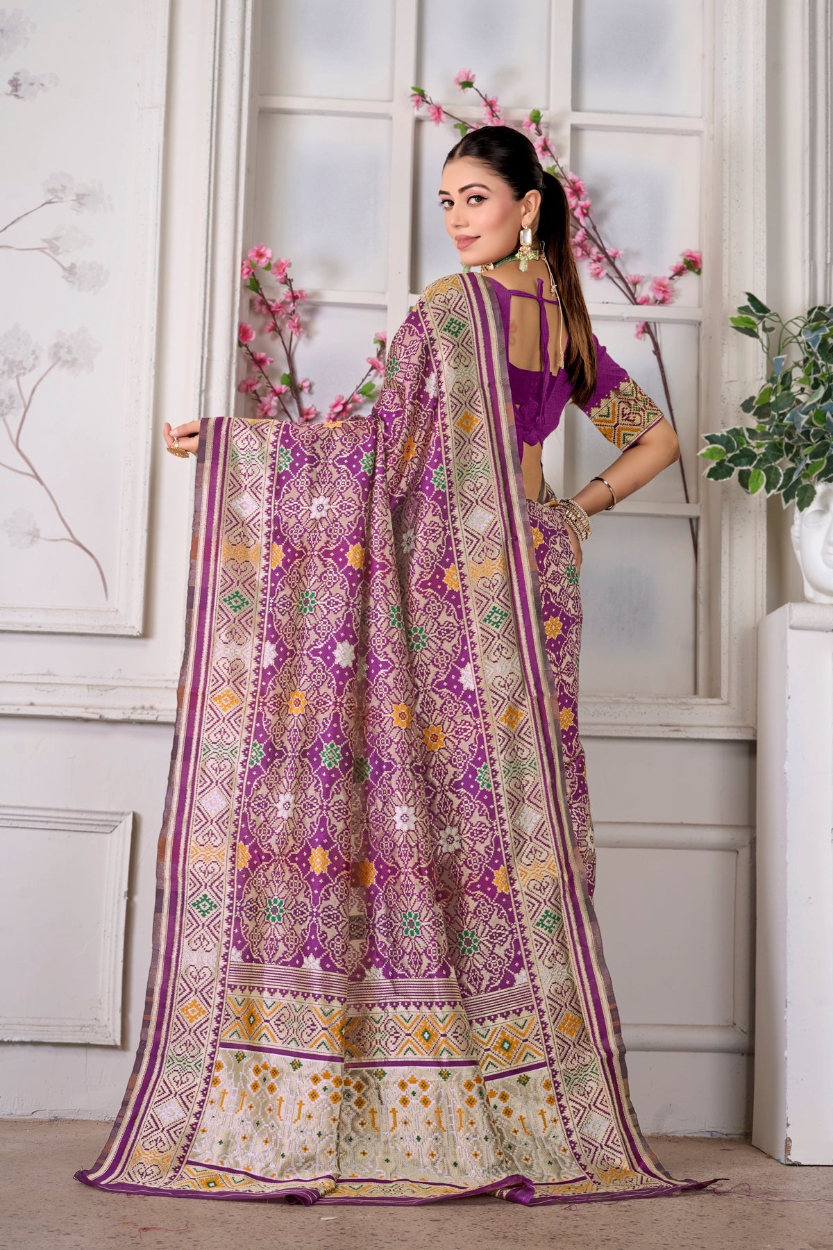 A wine Patola saree, pallu held open
