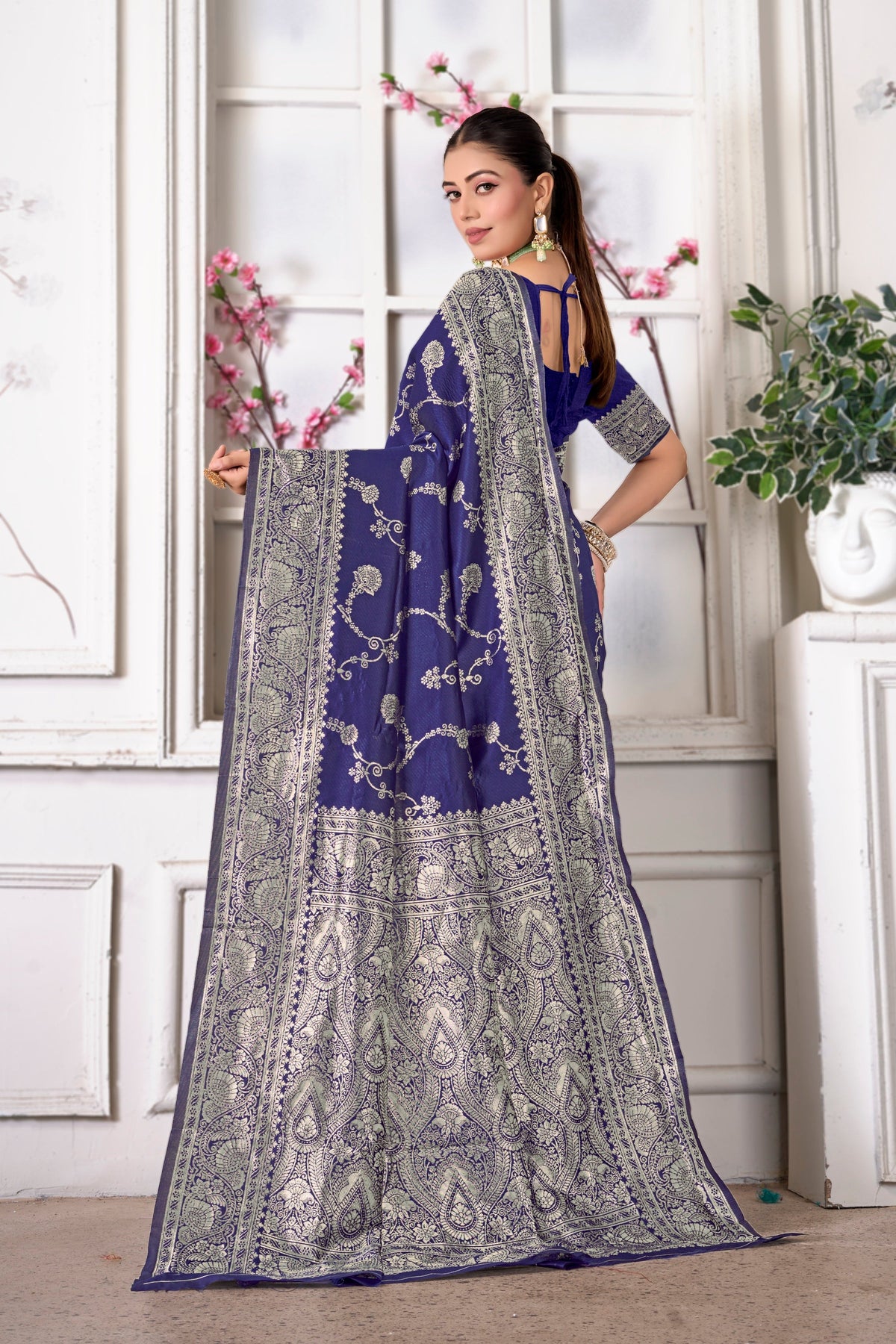 A navy blue Banarasi saree, pallu held open