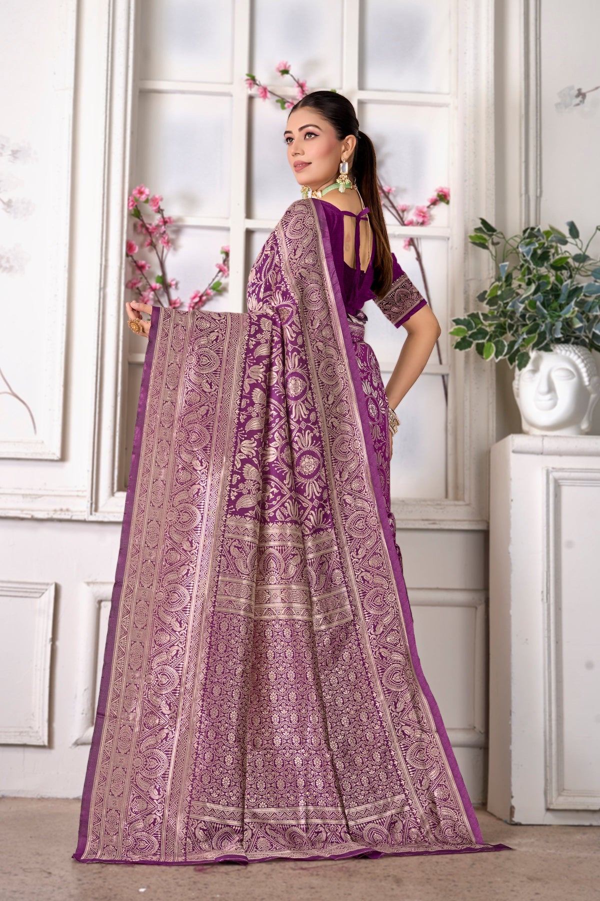 A wine Banarasi saree, pallu held open